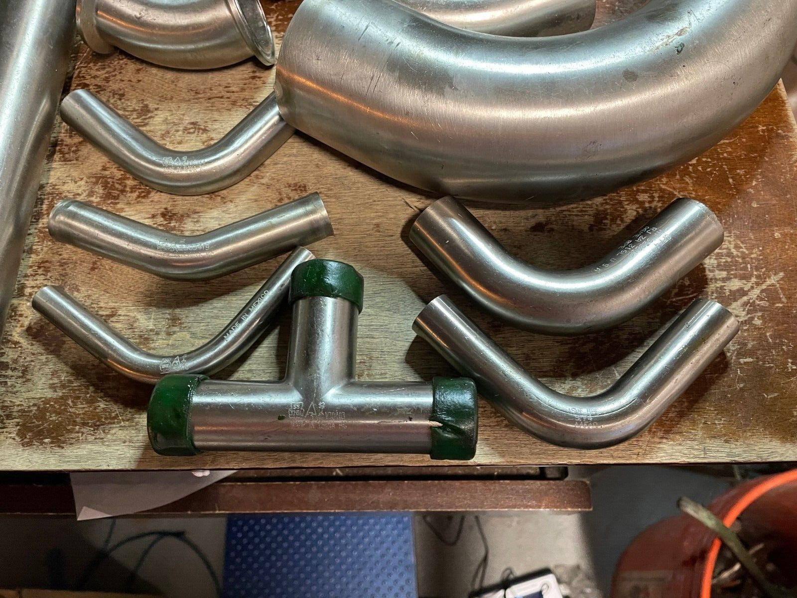 Assorted Lot of Stainless Steel Pipe Fittings, Unused Straight Elbows brewing